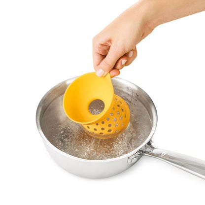 hand placing poacher into boiling water.