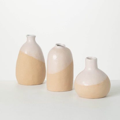 3 sozes of vases with organic shapes and creamy white glaze on top and terracotta on the bottom.