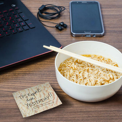 the ramen sticky notes sitting on a table beside a bowl of ramen and computer and cell phone