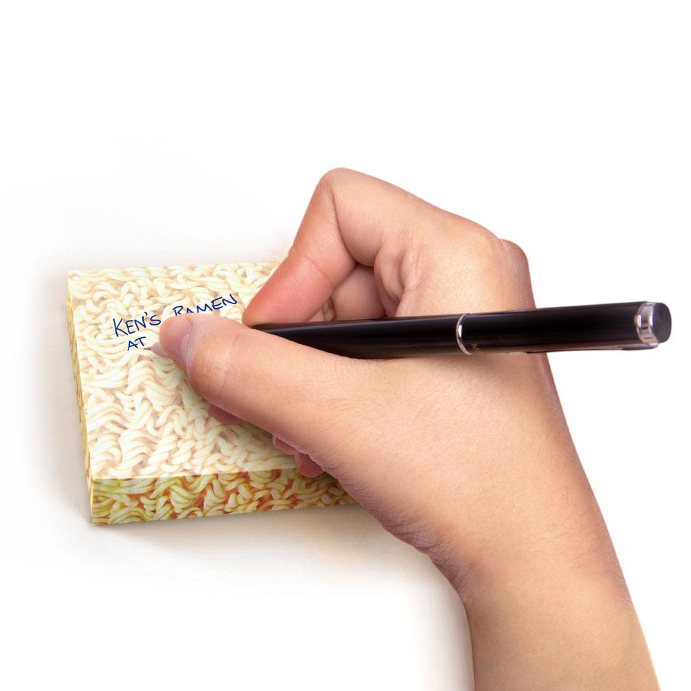 a person writing on the ramen sticky notes on a white background
