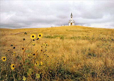 front of card is a photo of a prairie with a steeple church in the background
