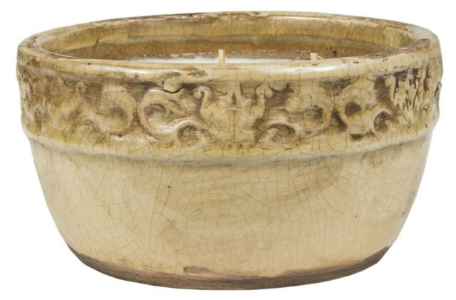 short round candle in beige canister with distressed finish.