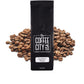 a black coffee bag filled with southern pecan coffee with a pile of coffee beans behind it on a white background