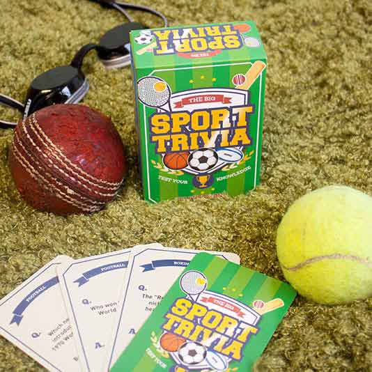 the sport trivia package and trivia cards displayed next to a tennis ball and swim goggles on tan carpet