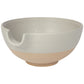 large off-white bowl with exposed terracotta base and pouring spout.