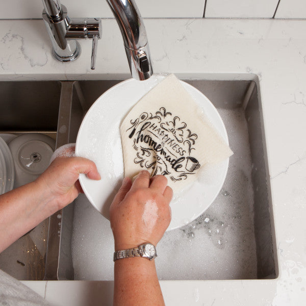 hands washing dishes with swedish dishcloth.