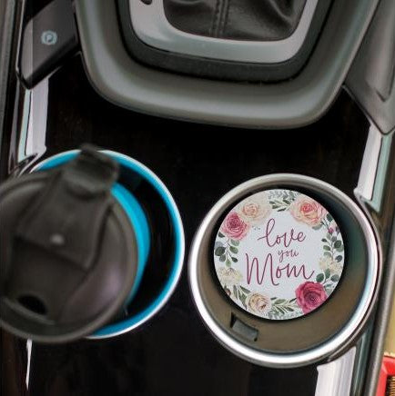 top view of the love you mom car coaster displayed in the cup holder in a car