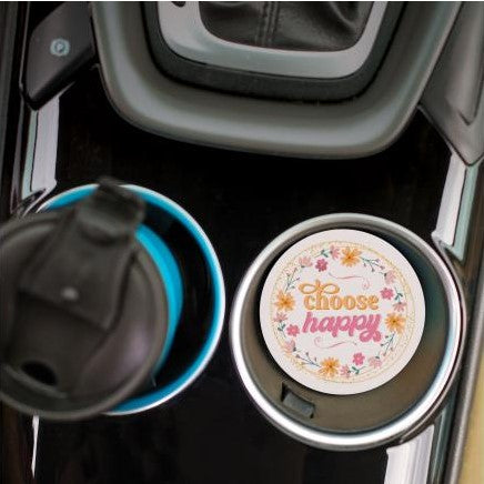 top view of the choose happy car coaster displayed in the cup holder in a car