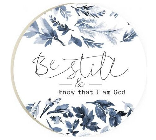 be still and know I am God round coaster is white with blue gray leaves and text displayed on a white background