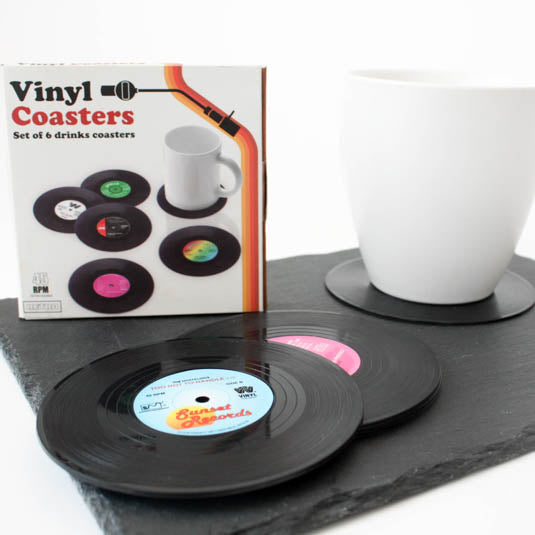 the vinyl coasters package displayed with they vinyl coasters on a piece of slate against a white background