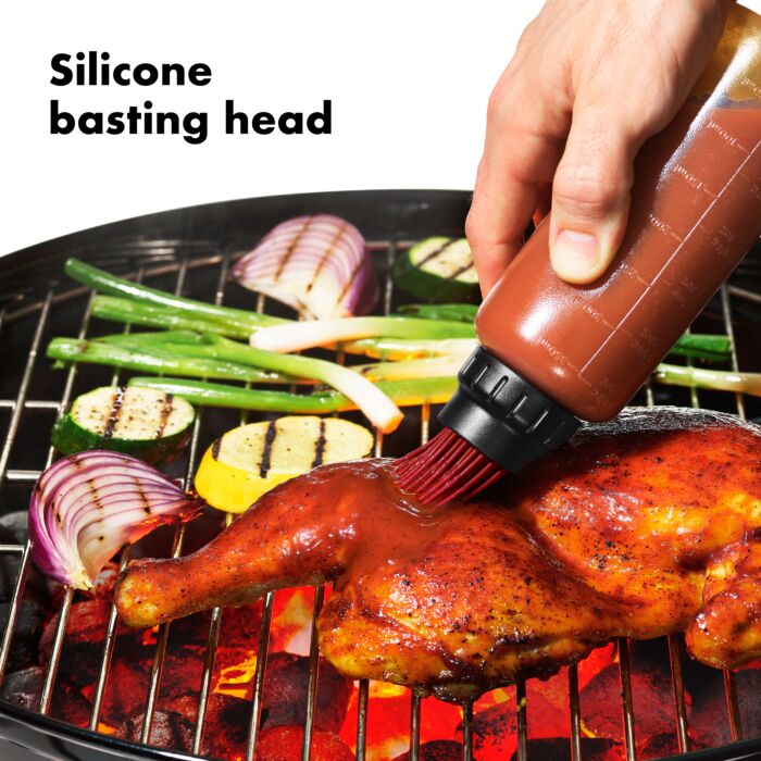 an illustration of the good grips grilling basting bottle being used while grilling chicken and veggies on a white background