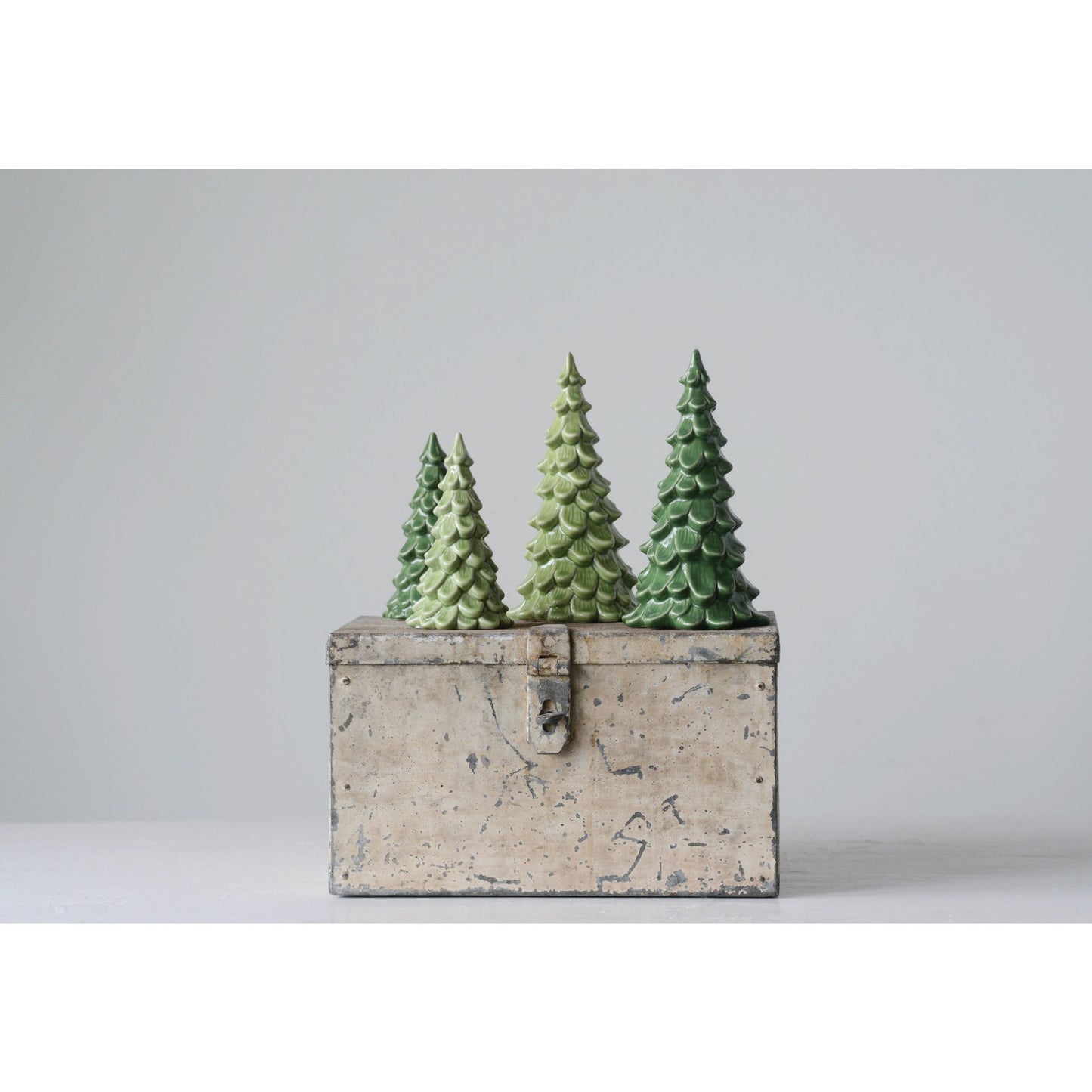 ceramic evergreen trees on a metal box.