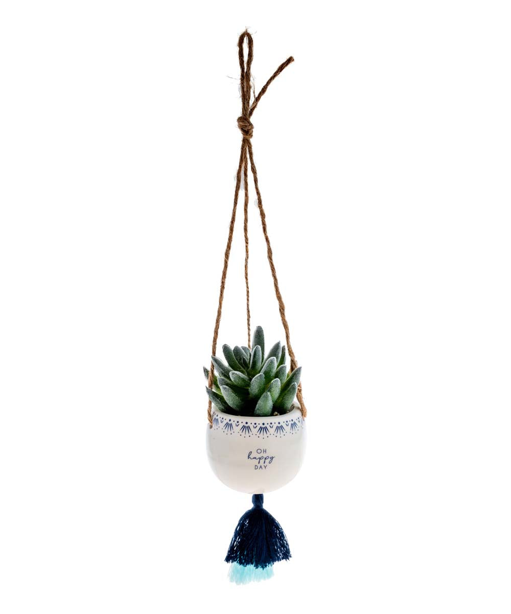 small ceramic pot with a succulent in it hanging form jute twine with a tassel on the bottom, a blue patterned boarder around the top and "oh happy day" printed on it.