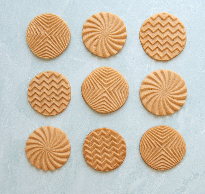 top view of 9 assorted cookies stamped with geometric designs.